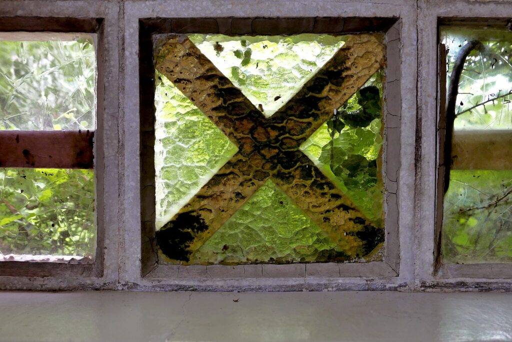 Sinnbild #256 X | großes X in brauner Farbe auf alten, grünlichen Fensterglas. (Bild von Adventuria® – Social Network & Journaling-Plattform, mit einem Tagebuch-Tool, einer unterstützenden Gemeinschaft und psychologischen Ratschlägen durch Podcasts)